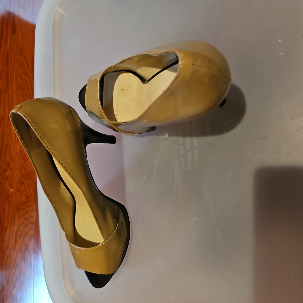 Tan patent leather peep toe pump.